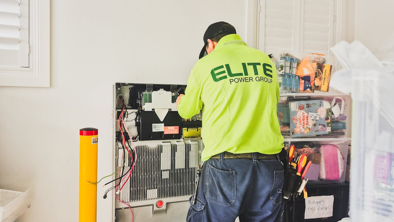 services-07 A technician from Elite Power Group installing a home battery system indoors in New South Wales, Australia.
